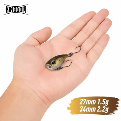 Small floating fish lure in dark green and silver with twin treble hooks.