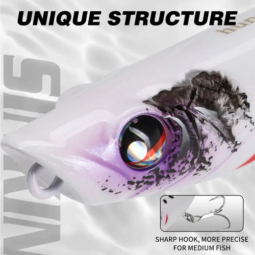 Topwater popper lure close-up, white body with purple-speckled face and rainbow eye