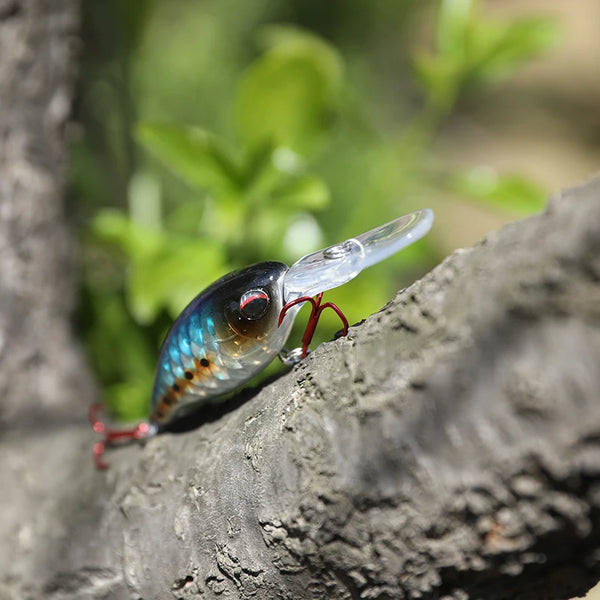 3D laser minnow crankbait with clear diving lip and red treble hooks on rock