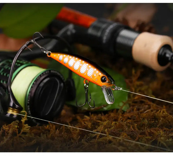 Sinking minnow fishing lure in bright orange with white spots and treble hooks