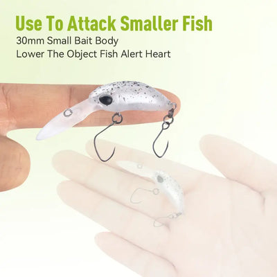 Floating artificial crankbait minnow lure, speckled white-gray, held in hand with hooks