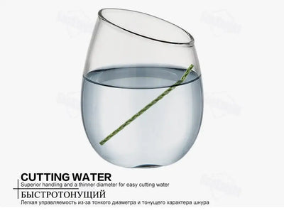 Green braided fishing line cutting through water in a glass bowl