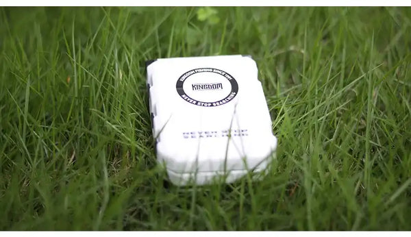 KINGDOM mini fishing tackle box storage case, white body with KINGDOM logo, outdoors on grass