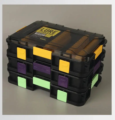 Stacked lure storage boxes with clear lids, yellow-purple-green front tabs and grid compartments