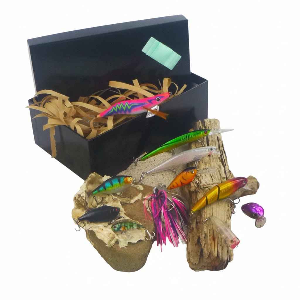 Fishing lure gift set, open black box with pink and green hard body lures on wood