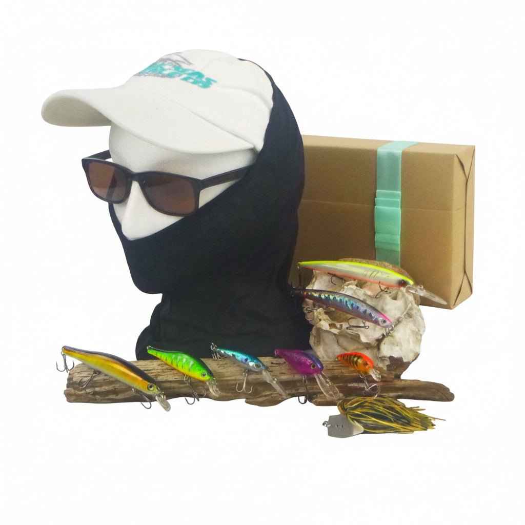 Cardboard box with assorted colorful hard-body fishing lures arranged on driftwood