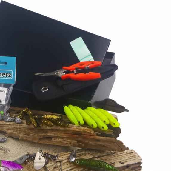 Tackle box set with green soft-plastic worms, orange baits, and jig heads