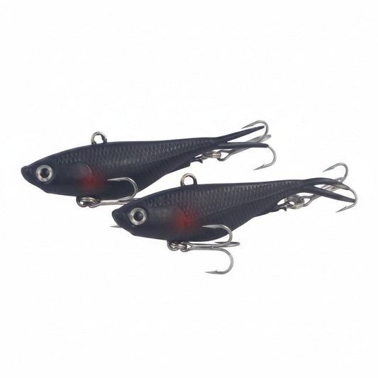 Two dark blue soft fishing lures with red belly spots, metal hooks, and split tail