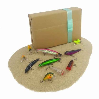 Surface lure gift set: brown box with turquoise strap, nine colorful crankbaits on sand